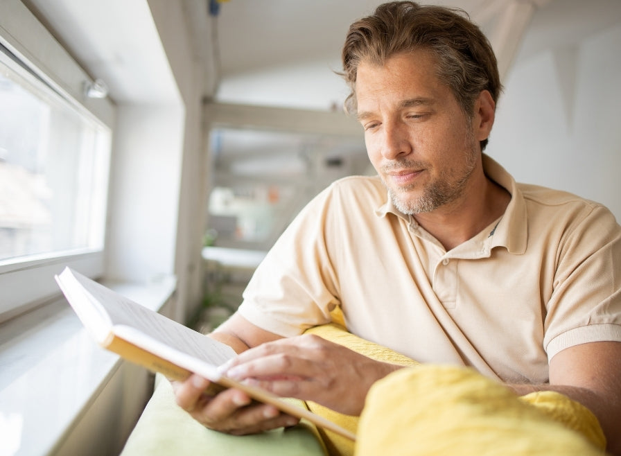 窓辺で読書をする男性