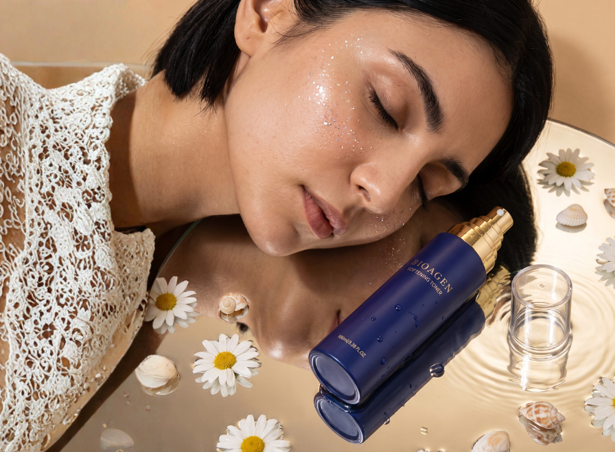 SOFTENING TONER ソフニングトナーのボトルと花のそばでくつろぐ女性